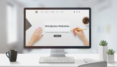 Desktop computer displaying a WordPress website design on a clean white desk